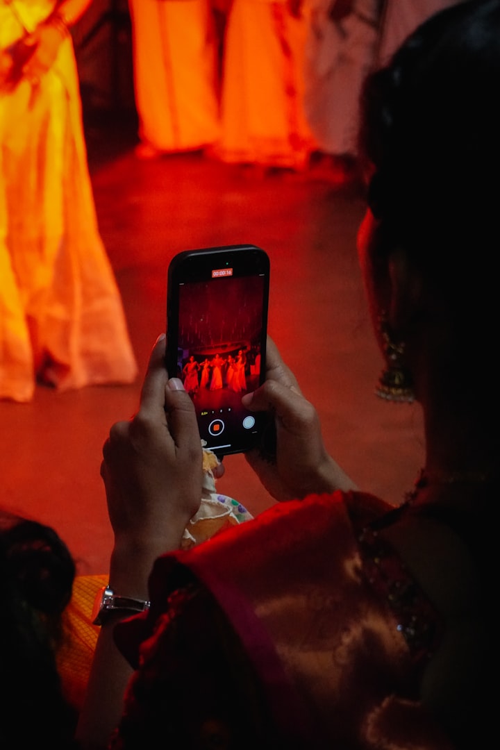 Woman records performance on smartphone with smartphone
